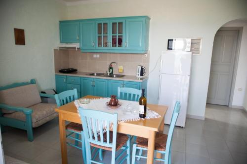 a kitchen with blue cabinets and a table and chairs at Liviko View in Xerokampos