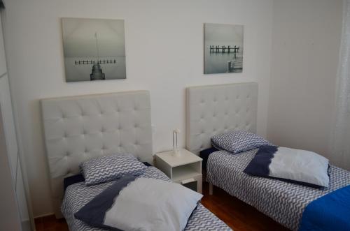 two beds in a room with two pictures on the wall at VV Sarmiento in Vecindario