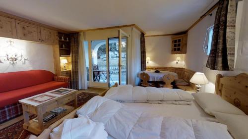 ein Wohnzimmer mit einem großen Bett und einem roten Sofa in der Unterkunft Guardalej 205 in Champfer