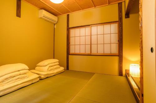 a room with two white towels sitting on a bed at 一棟まるまる貸切宿 10名様まで Guesthouse Gokurakudo in Kyoto