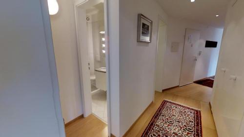 einen Flur mit Bad mit WC und Teppich in der Unterkunft Paravicini in St. Moritz