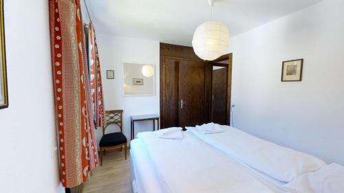 ツェエリーナにあるCollinaのベッドルーム(白いベッド1台、椅子付)