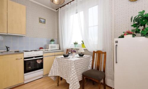 モスクワにあるApartment na Kozhukhovskoiのキッチン(テーブル、白い冷蔵庫付)