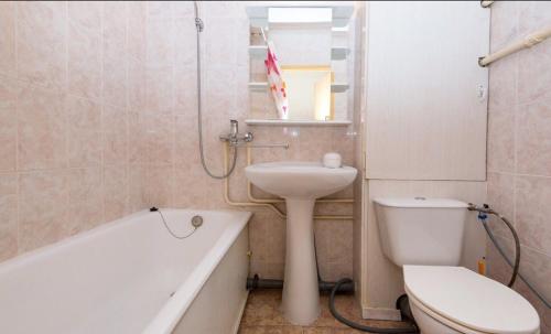 モスクワにあるApartment na Kozhukhovskoiのバスルーム(洗面台、トイレ、バスタブ付)