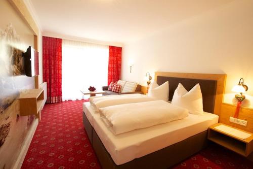 a bedroom with a large bed in a hotel room at Hotel Garni Larcherhof in Mayrhofen