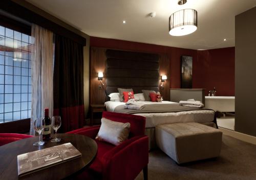 a hotel room with two beds and a table and chairs at The Mere Golf Resort & Spa in Knutsford