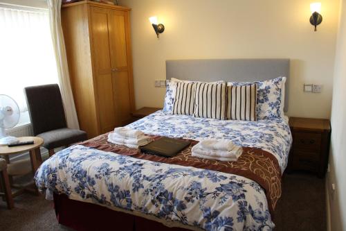 a bedroom with a bed with blue and white sheets at The Homestar in Skegness