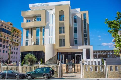 a building with cars parked in front of it at Hotel Vila Koral in Durrës