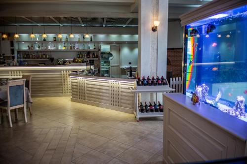 a restaurant with a bar and a fish tank at Hotel Vila Koral in Durrës
