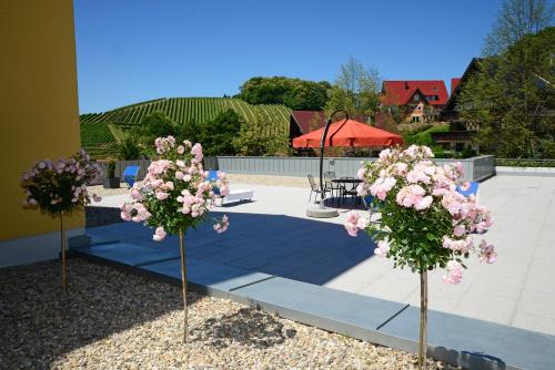 two trees with pink flowers in the middle of a patio at Residence am Weinberg / Travellers Hotelbetriebs GmbH in Sasbachwalden