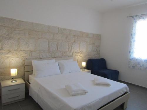 1 dormitorio con 1 cama blanca y 1 silla azul en Blu Maris Sicilia Guesthouse, en Marina di Ragusa