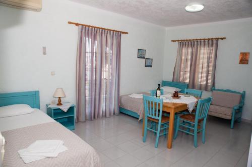 a room with a bed and a table and chairs at Liviko View in Xerokampos