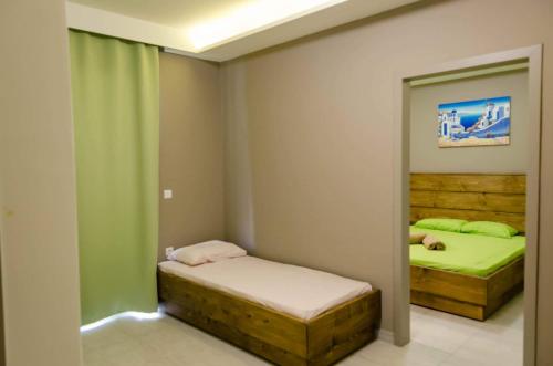 Habitación pequeña con 2 camas y espejo. en Maestro Apartments Faliraki en Faliraki