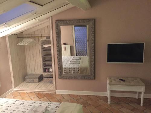 specchio in camera con letto e TV di Key's House a Parma