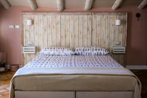 una camera con un grande letto con testiera in legno di Key's House a Parma