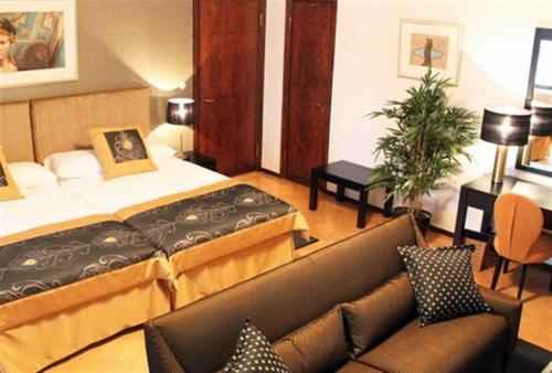 une chambre d'hôtel avec un lit et un canapé dans l'établissement Art Hotel Honkahovi, à Mänttä