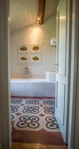 a bathroom with a tub and a shower with a tile floor at Castello Di Mornico Losana in Mornico Losana