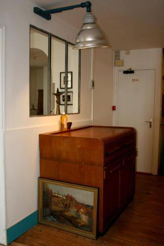 a room with a table with a mirror and a picture at La Maison de la Plage in Trouville-sur-Mer