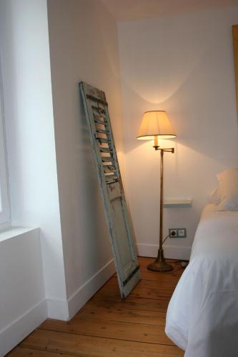 a room with a ladder on the wall next to a bed at La Maison de la Plage in Trouville-sur-Mer