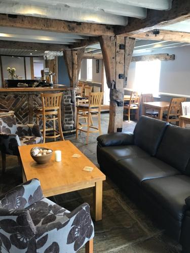 a living room filled with furniture and a table at The Cherry Tree Inn in Ticehurst