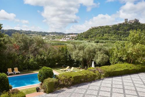 a resort with a swimming pool and a hill at Casa D Obidos in Óbidos