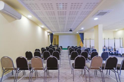 a room with rows of chairs and a table at Hotel Riviera dei Fiori in San Lorenzo al Mare