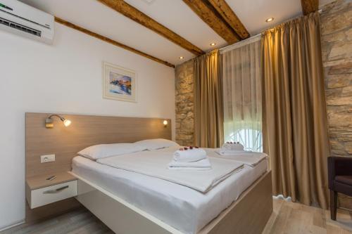 Schlafzimmer mit einem Bett und einem Fenster in der Unterkunft Minella Residence in Poreč