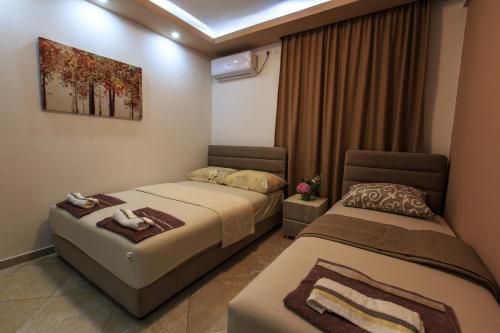 a hotel room with two beds and a window at De Lux Apartments Luka in Bar
