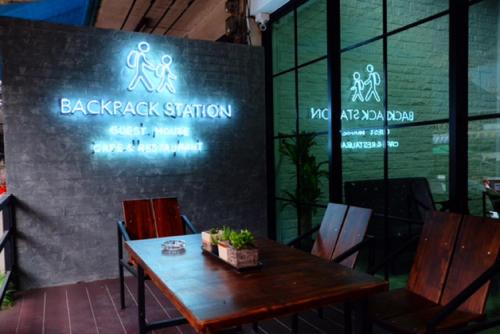 a table and chairs in a restaurant with neon signs at Backpack Station in Bangkok