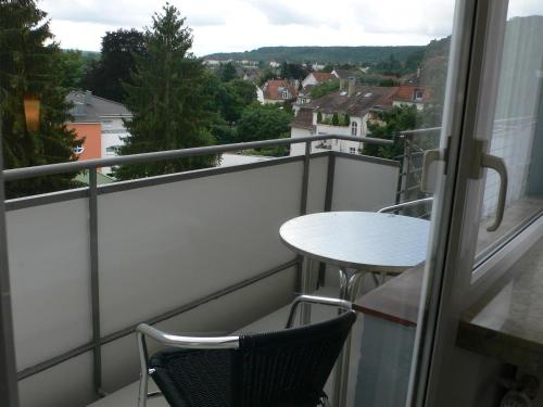 a balcony with a table and chairs and a view at Hotel Meran Hallenbad & Sauna in Saarbrücken