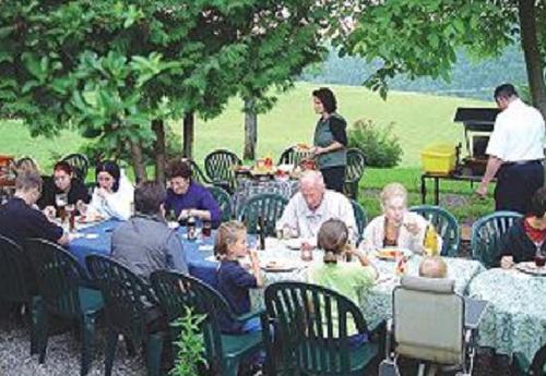 Eine Gruppe von Menschen, die an einem Tisch sitzen und essen in der Unterkunft Gasthaus und Pension Hintere Höfe in Freiamt