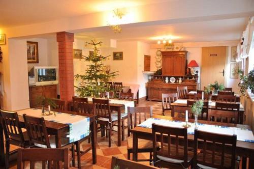 een restaurant met tafels en stoelen en een kerstboom bij Willa Emi in Karpacz