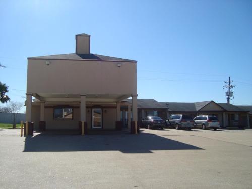 a building with cars parked in a parking lot at Navasota Inn in Navasota