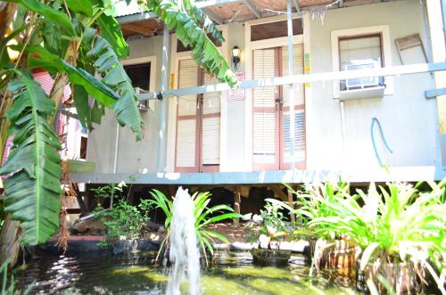 a pond in front of a building with a fountain at India House Hostel in New Orleans