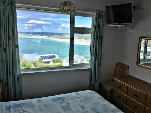 sypialnia z oknem z widokiem na ocean w obiekcie Surf View Apartments w Newquay