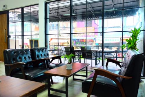 a restaurant with chairs and tables and a large window at Backpack Station in Bangkok