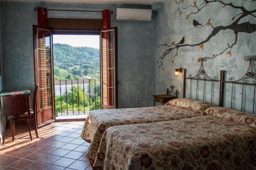 um quarto com 2 camas e uma grande janela em Aparthotel Rural 12 Caños em Galaroza