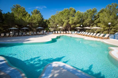 a swimming pool with chairs and umbrellas at a resort at Insotel Club Maryland in Playa Migjorn