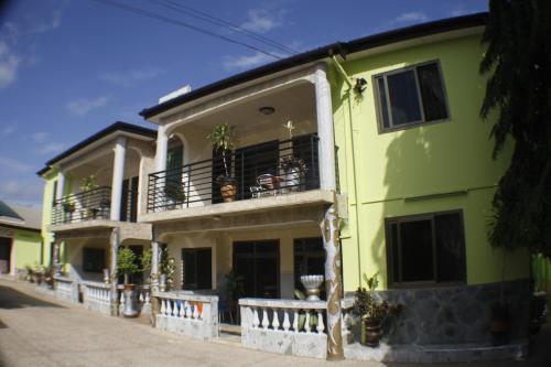 un edificio giallo con balcone con piante di Dokua Royal Hotel a Accra