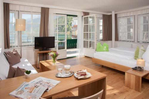 a living room filled with furniture and a tv at Hotel Brandauers Villen Superior in Strobl