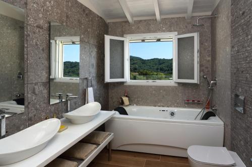 La salle de bains est pourvue d'une baignoire, d'un lavabo et de toilettes. dans l'établissement Villa Vozos, à Arillas