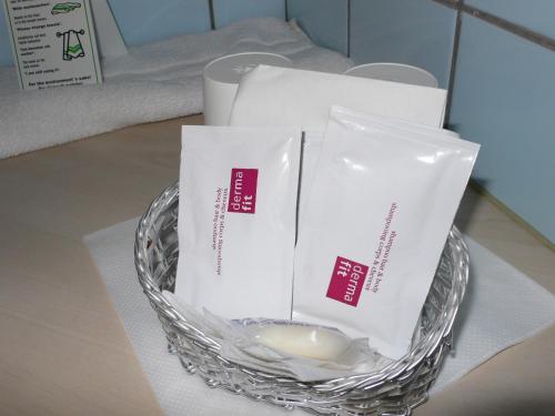 a glass bowl with three packets ofentedented soap in it at Hotel Meran Hallenbad & Sauna in Saarbrücken