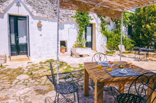 a wooden table and chairs on a patio at Masseria Rosa Trulli Relais in Alberobello