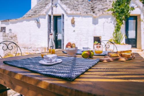 a wooden table with a plate of food on it at Masseria Rosa Trulli Relais in Alberobello