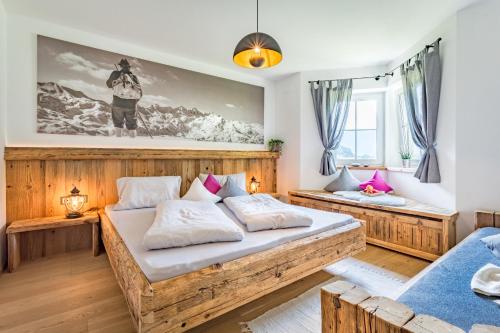 a bedroom with two beds and a large painting on the wall at Landhaus Theresia in Maria Alm am Steinernen Meer