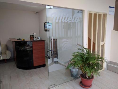 薩利納斯的住宿－Hotel Mileto，一个人站在大厅的玻璃门后面
