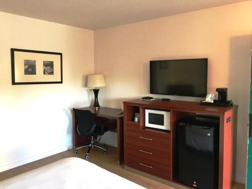 a hotel room with a television and a desk with a computer at Diablo Mountain Inn Walnut Creek in Walnut Creek