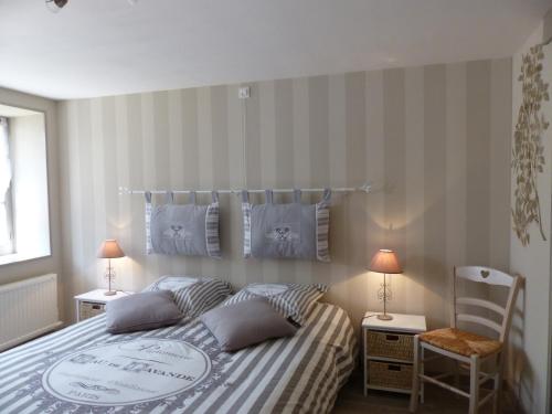 a bedroom with a bed and two lamps and a chair at La Maison aux Hortensias in Verneuil-en-Bourbonnais