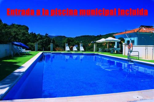 una gran piscina azul en un patio en Casa Rural Fuente Caraila, en Júzcar