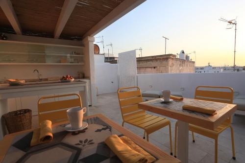 a kitchen with a table and chairs on a balcony at FONTEblu B&B in Polignano a Mare